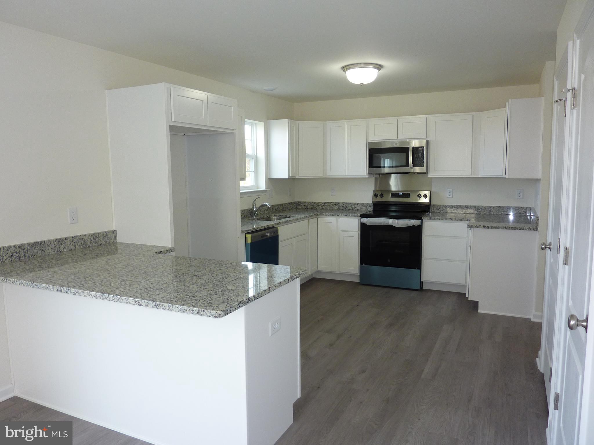 272 Doylestown Road Smyrna, DE 19977 - Photo 9 of 34 a kitchen with stainless steel appliances granite countertop a sink a stove top oven a counter space and cabinets