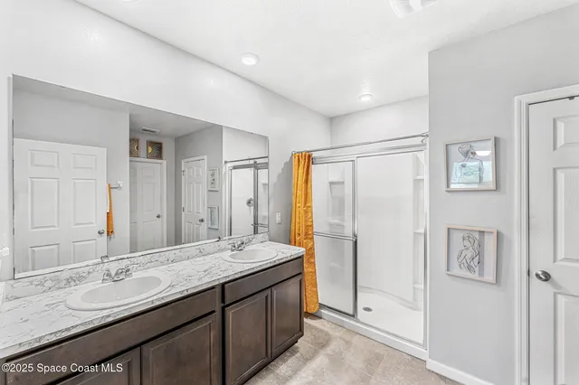 a bathroom with a granite countertop double vanity sink and a mirror