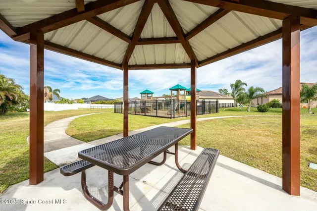a view of a swimming pool with a yard and palm trees