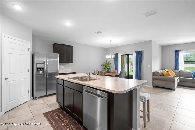 a kitchen with stainless steel appliances granite countertop a sink and a refrigerator