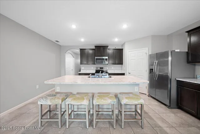 a kitchen with kitchen island a dining table and stainless steel appliances