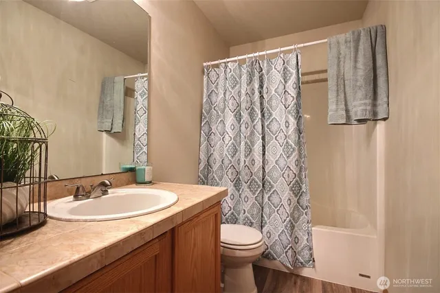 a bathroom with a granite countertop sink toilet and a mirror