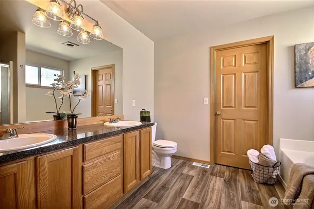 a bathroom with a double vanity sink a toilet and a mirror