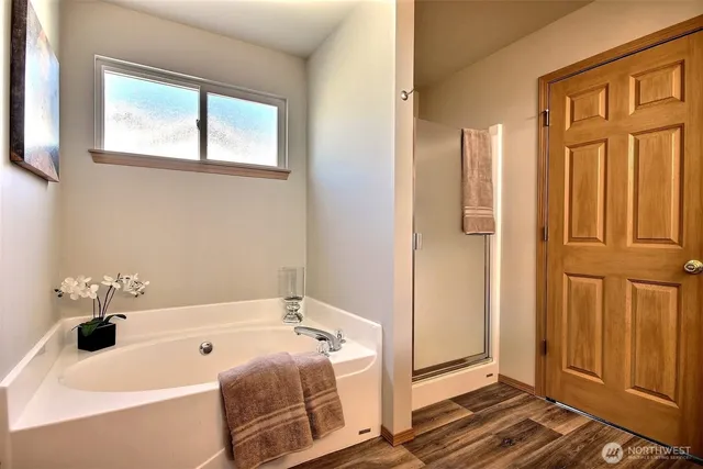 a bathroom with a tub a sink and a window