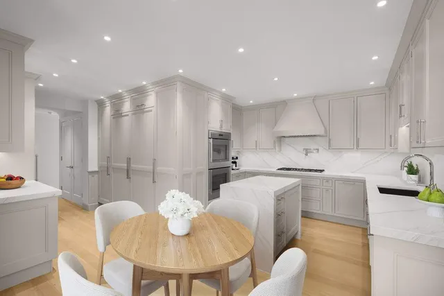 a kitchen with kitchen island a white counter top space a sink appliances and chairs