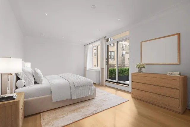 a spacious bedroom with a bed and a dresser