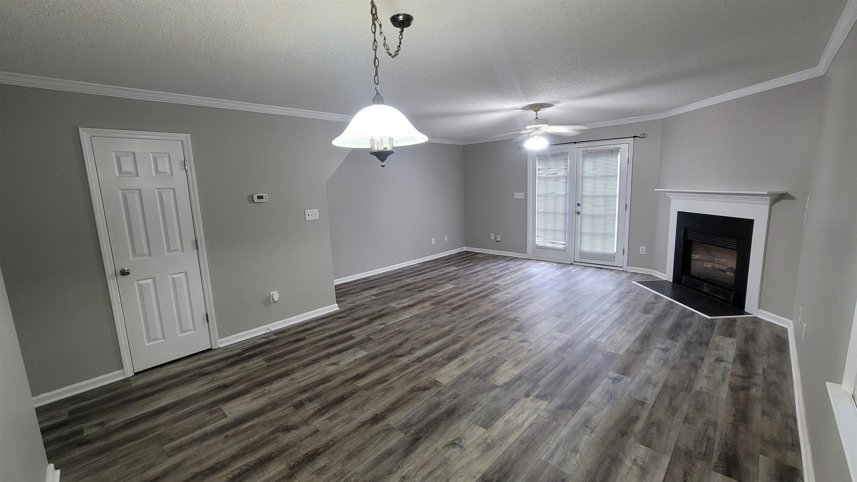 3809 Axle Lane Raleigh, NC 27616 - Photo 26 of 30 a view of an empty room with wooden floor fireplace and a window