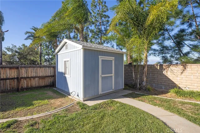 a view of backyard with small cabin and wooden fence