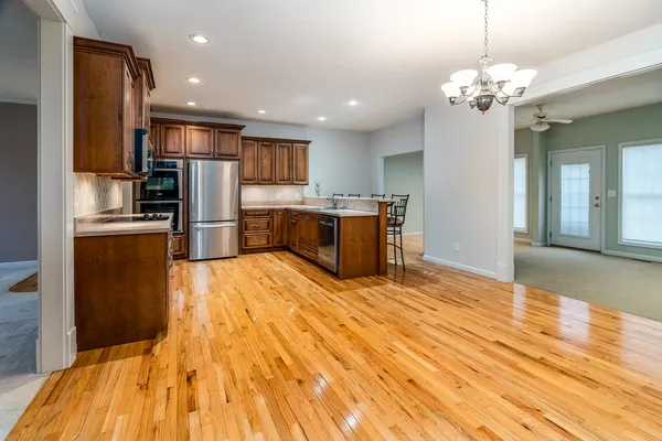 a view of an empty room with furniture and wooden floor