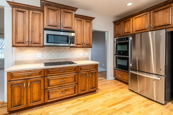 a kitchen with stainless steel appliances granite countertop a refrigerator microwave and sink