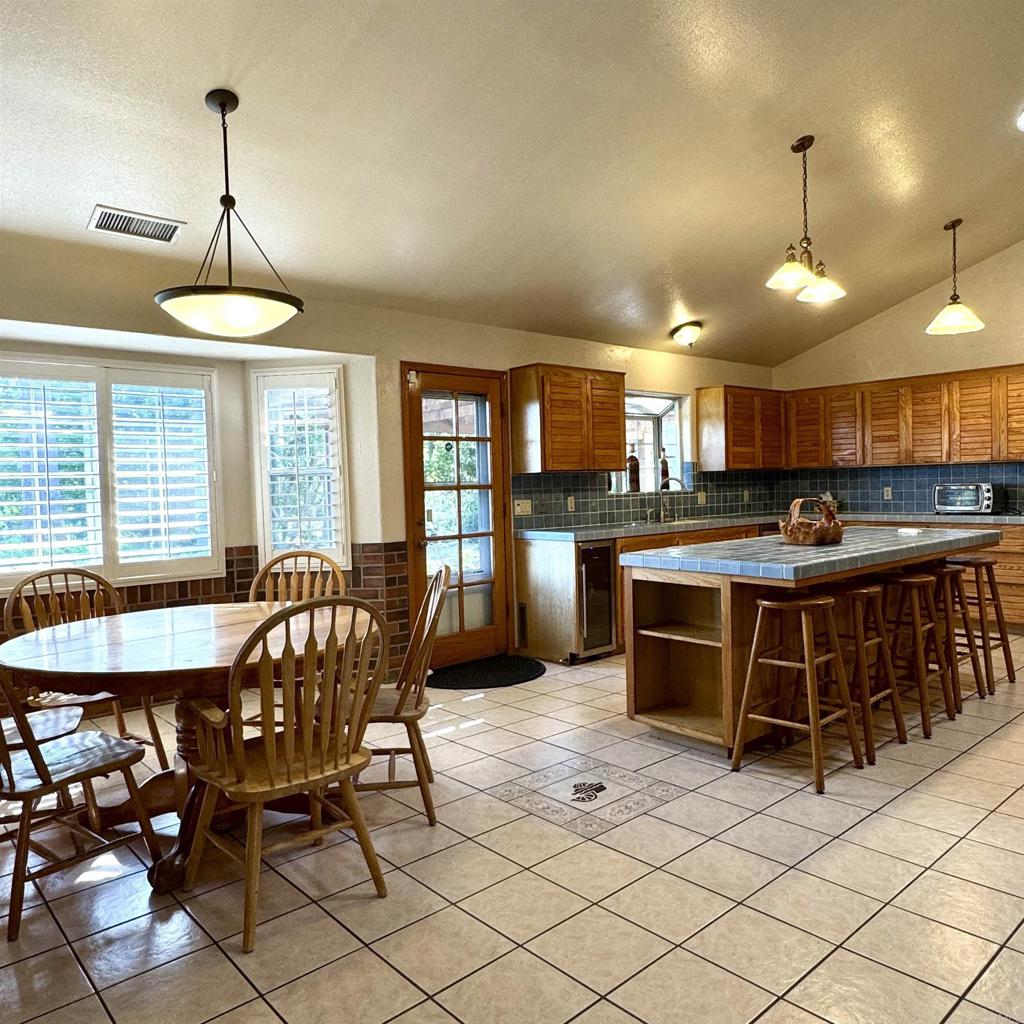 2848 Los Alisos Drive Fallbrook, CA 92028 - Photo 19 of 74 a kitchen with stainless steel appliances granite countertop a stove a sink a counter space a dining table and chairs with wooden floor