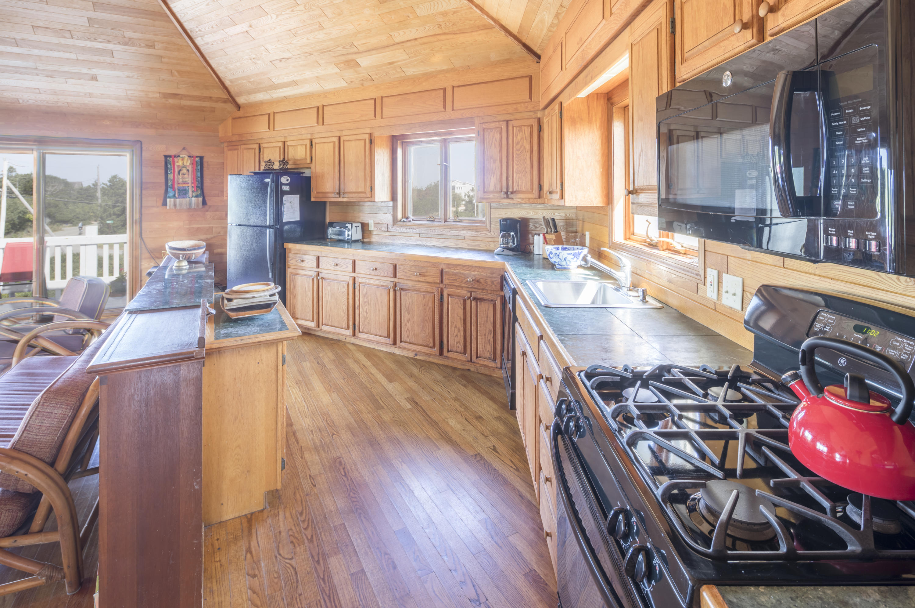 34 Bay View Road Truro, MA 02666 - Photo 7 of 14 a large kitchen with stainless steel appliances wooden floors and wooden cabinets