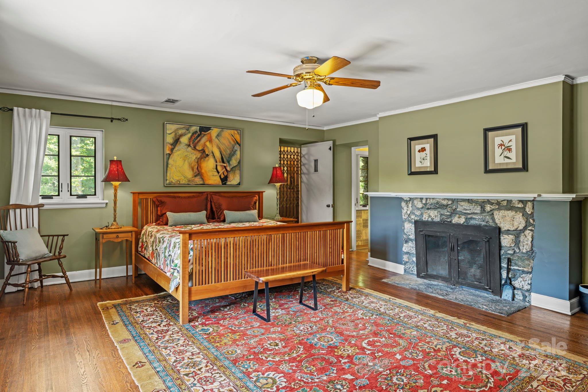 222 Stone Hedge Lane Tryon, NC 28782 - Photo 19 of 48 a bedroom with a bed and a fireplace