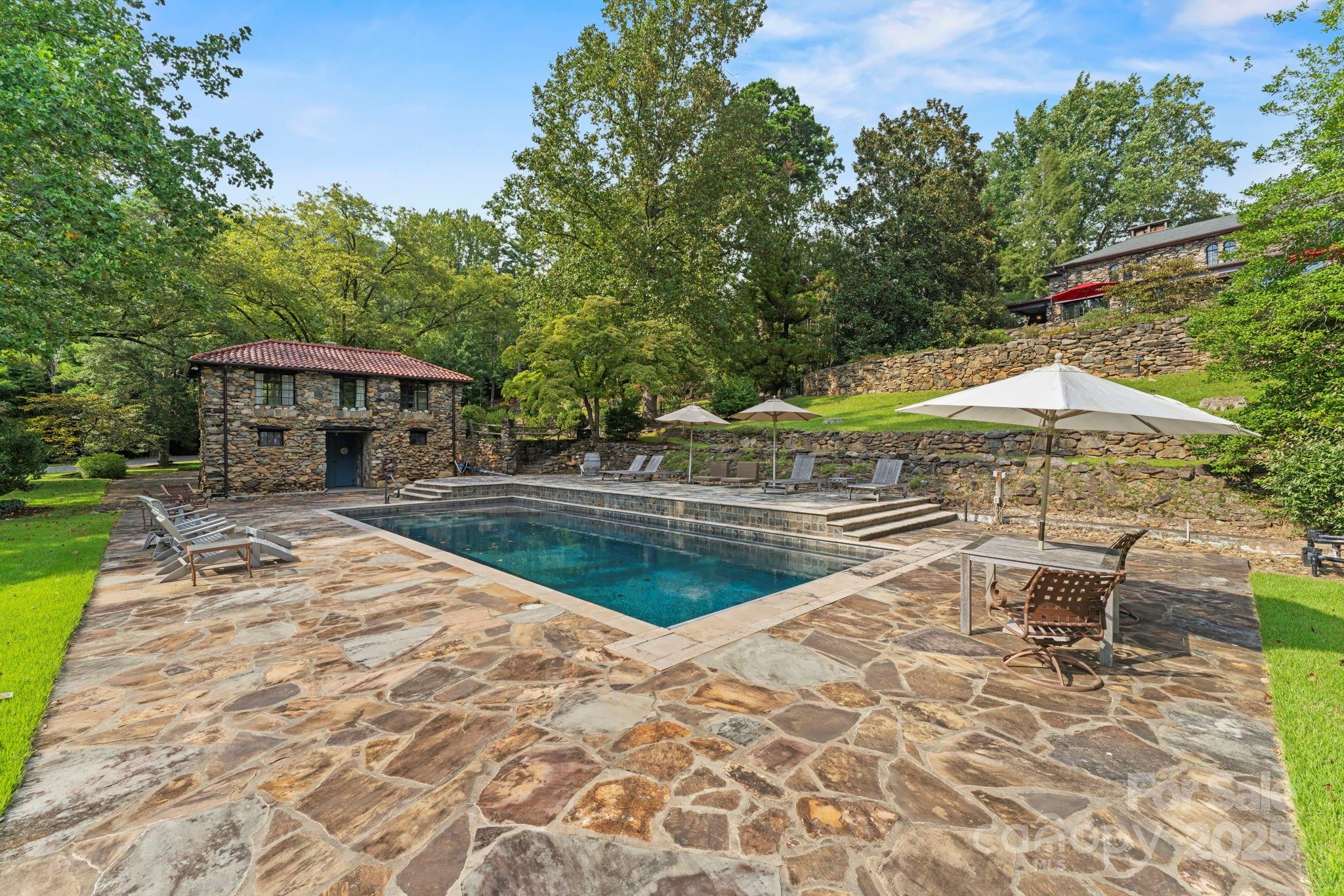 222 Stone Hedge Lane Tryon, NC 28782 - Photo 43 of 48 a view of swimming pool with lawn chairs under an umbrella