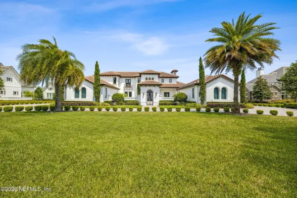 front view of house with a garden and palm trees