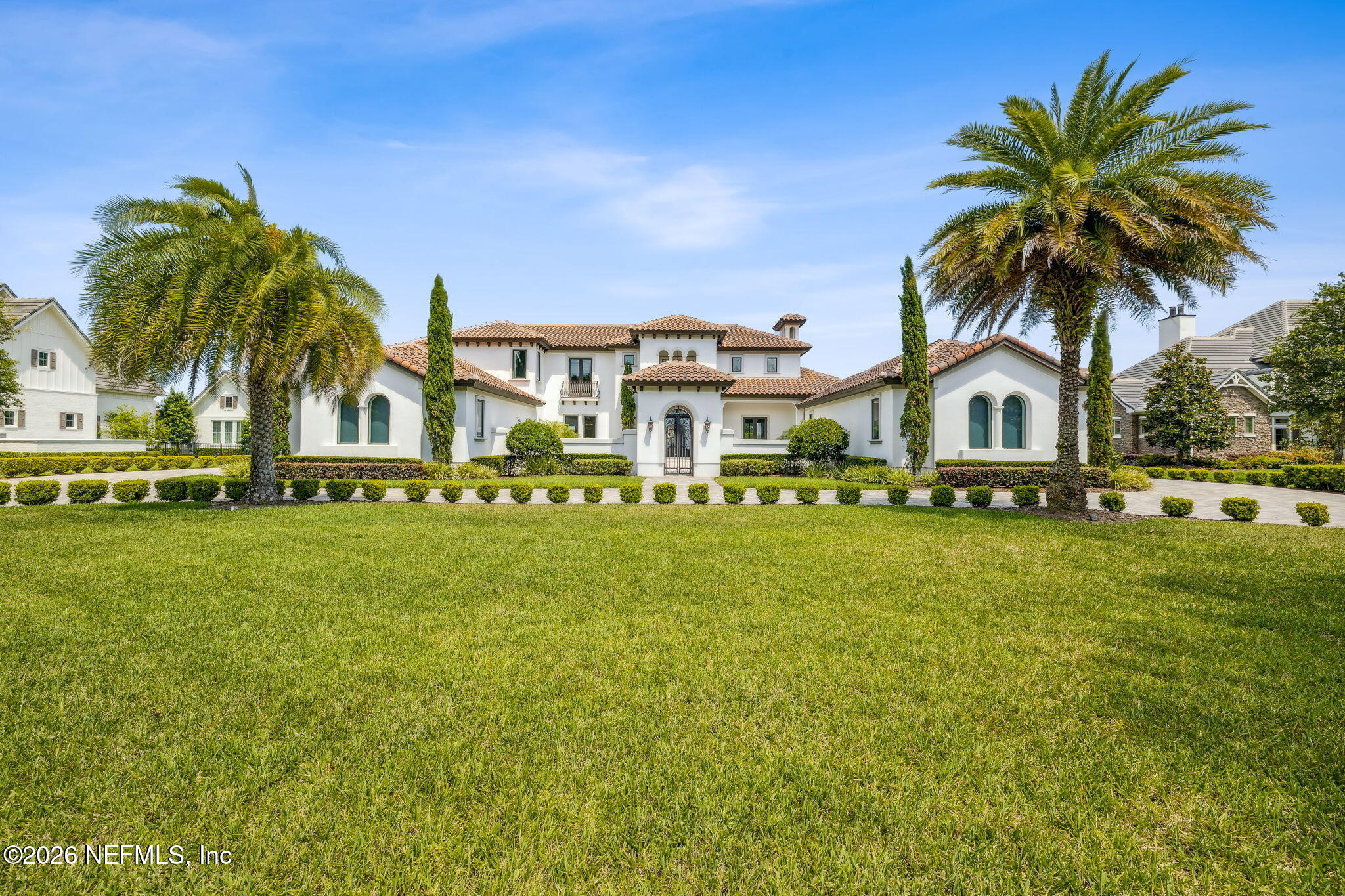 front view of house with a garden and palm trees