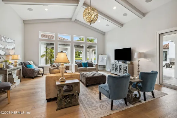 a living room with furniture a flat screen tv and a large window