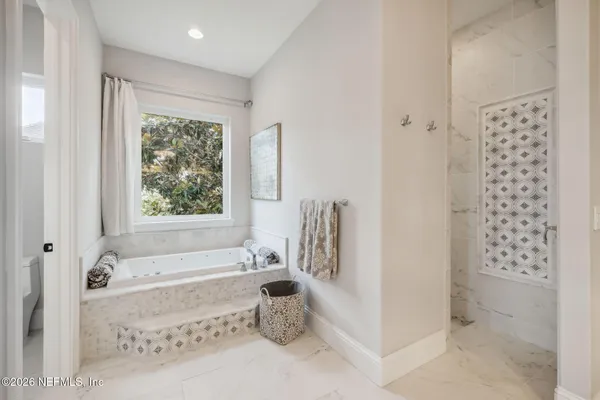 a living room with furniture a flat screen tv and a floor to ceiling window