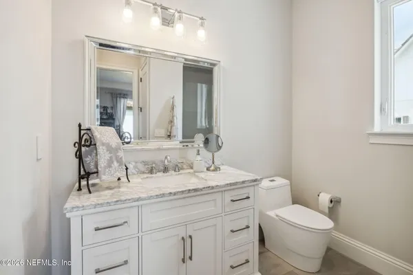 a bathroom with a granite countertop sink mirror and a toilet