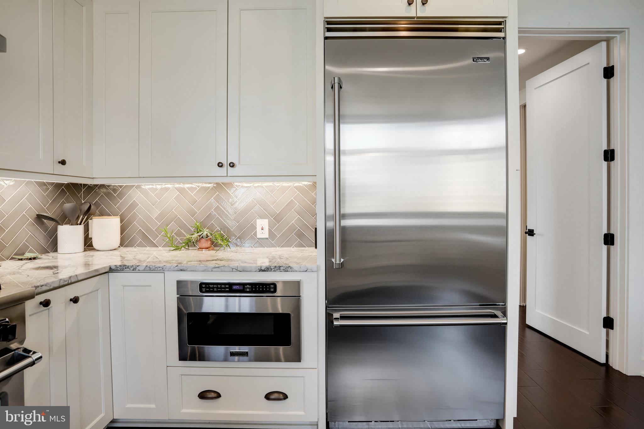 1000 New Jersey Avenue Southeast, Unit 1020 Washington, DC 20003 - Photo 17 of 60 a kitchen with a refrigerator and white cabinets