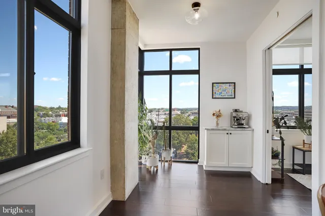 a kitchen with stainless steel appliances granite countertop a stove a sink a refrigerator and a dining table with wooden floor