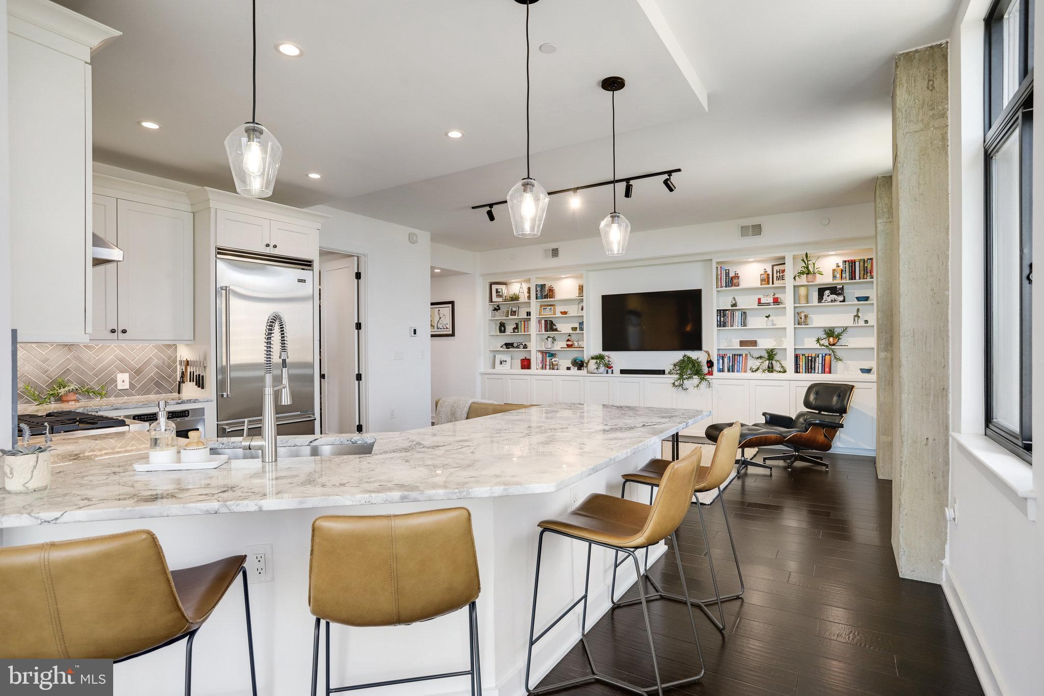 1000 New Jersey Avenue Southeast, Unit 1020 Washington, DC 20003 - Photo 2 of 60 a kitchen with stainless steel appliances granite countertop a stove a sink a kitchen island a dining table and chairs with wooden floor