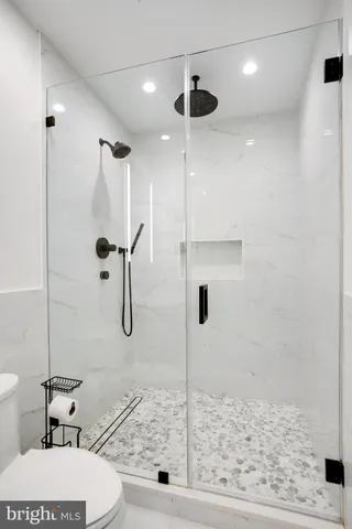 a bathroom with a granite countertop sink toilet and shower