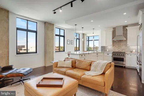 a living room with furniture flat screen tv and a window