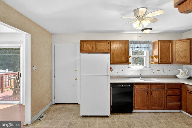 a front view of a house with a yard and trees