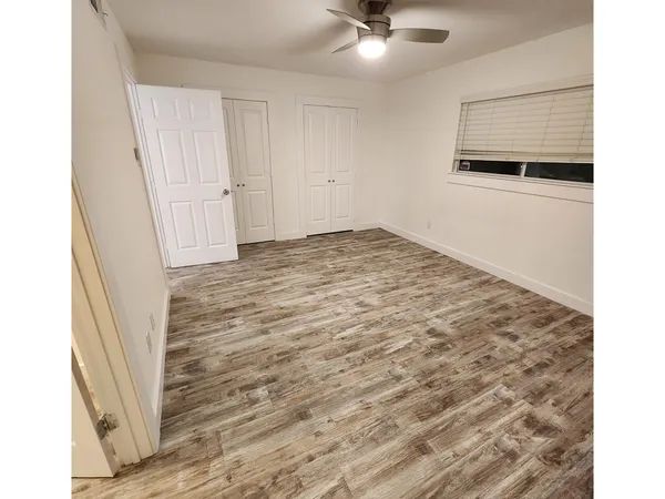 a view of a room with wooden floor and white walls