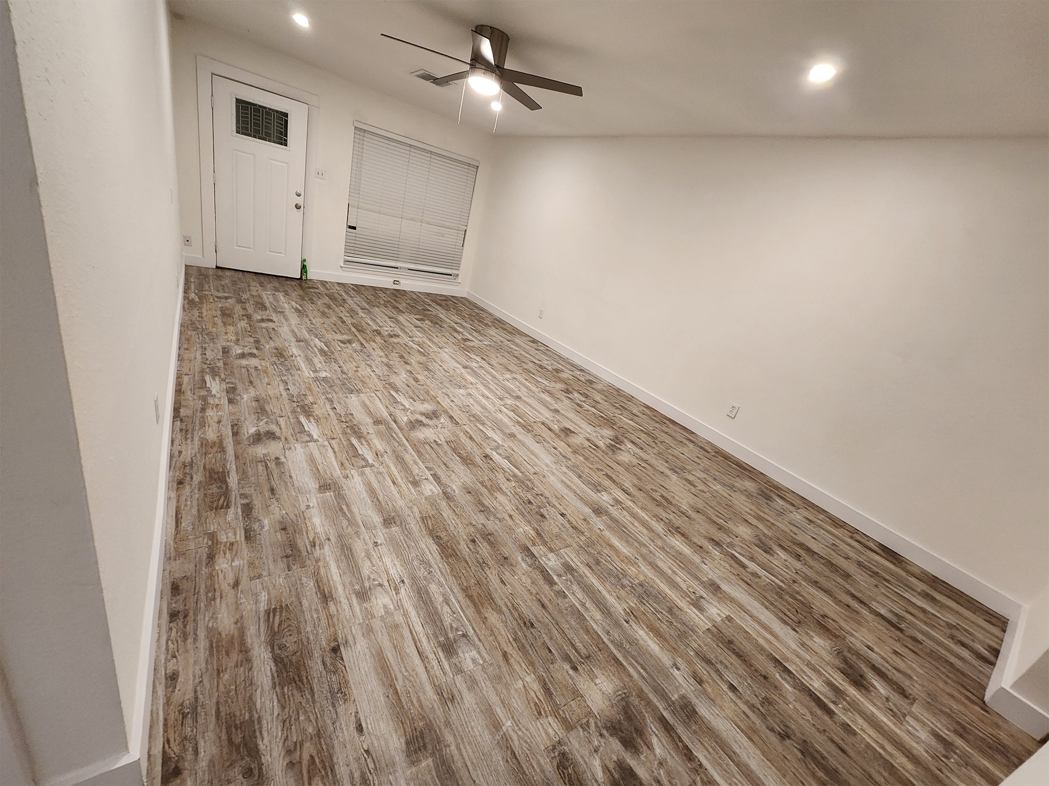 2677 Gessner Road, Unit 203 Houston, TX 77080 - Photo 6 of 11 en empty room with wooden floor ceiling fan and window