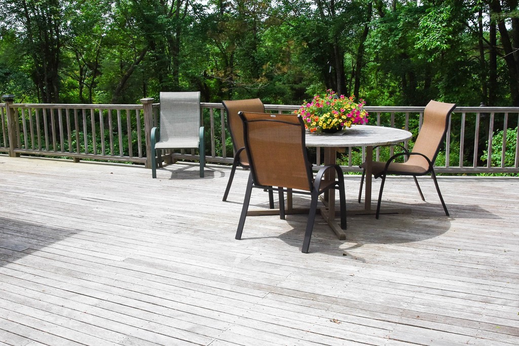 14 Forge Way Duxbury, MA 02332 - Photo 22 of 26 a view of a roof deck with table and chairs a barbeque with wooden floor and fence