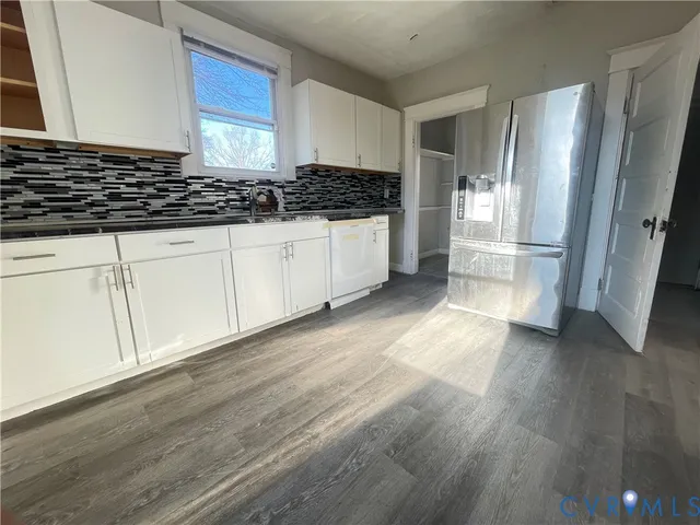 a kitchen with stainless steel appliances a refrigerator and wooden floor