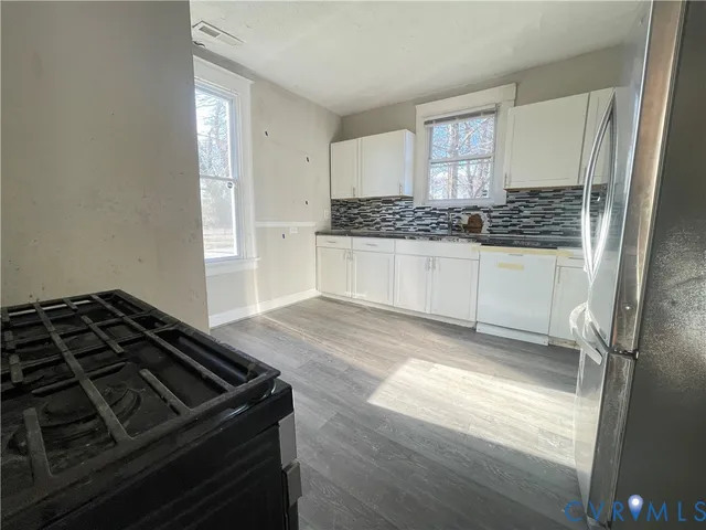 a kitchen with a stove and white cabinets