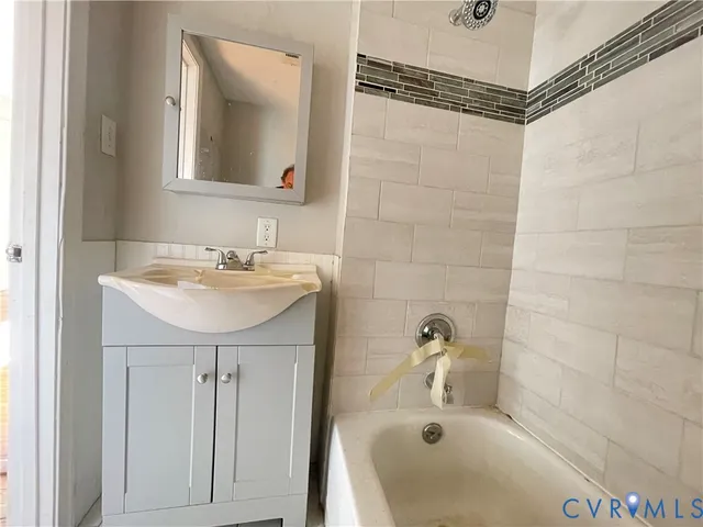 a bathroom with a sink a mirror and a bathtub