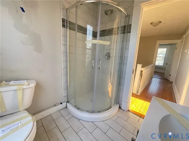 a bathroom with a toilet and a shower