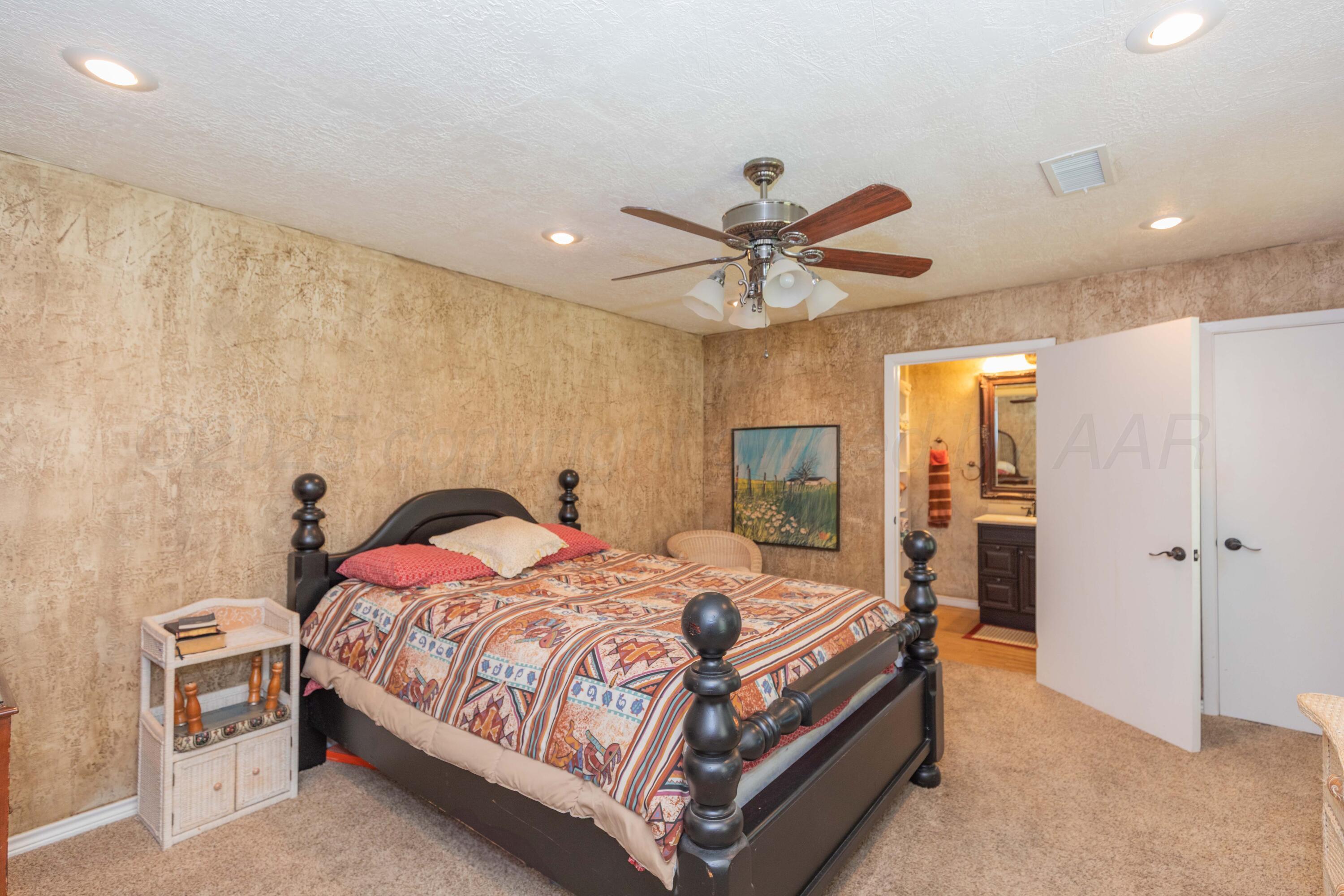 209 East 12th Street Wheeler, TX 79096 - Photo 15 of 40 a bedroom with a bed and a chandelier