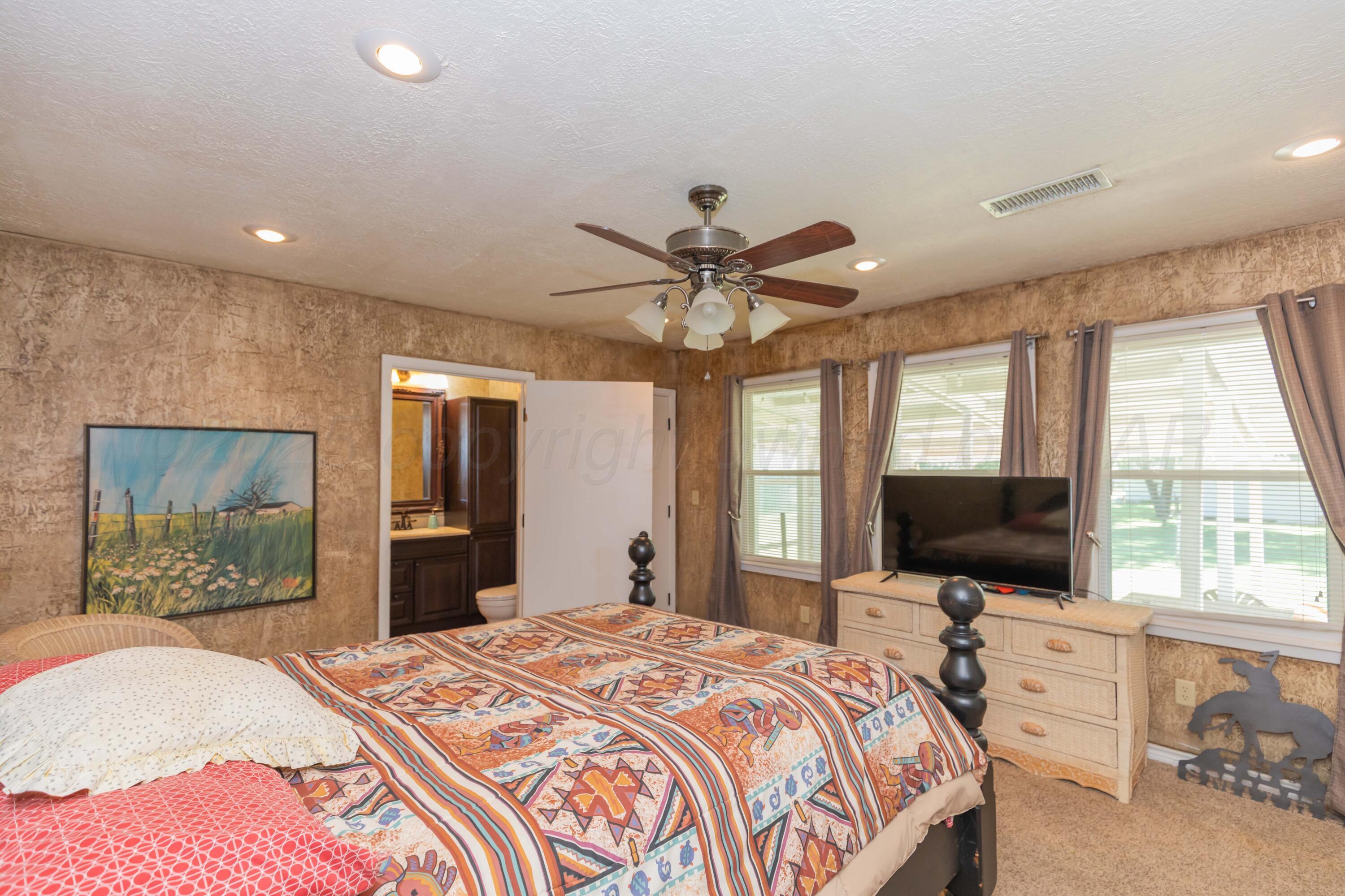 209 East 12th Street Wheeler, TX 79096 - Photo 16 of 40 a bedroom with a bed and a flat screen tv