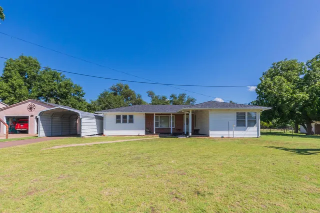a view of a house with a patio and a yard