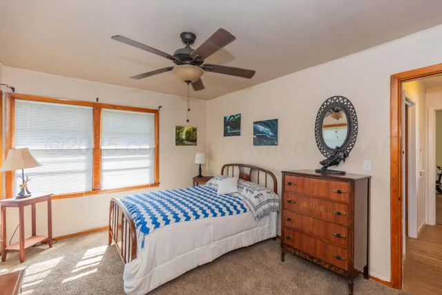 a bedroom with a bed a dresser and a window