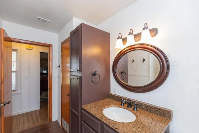 a bathroom with a sink a mirror and a window