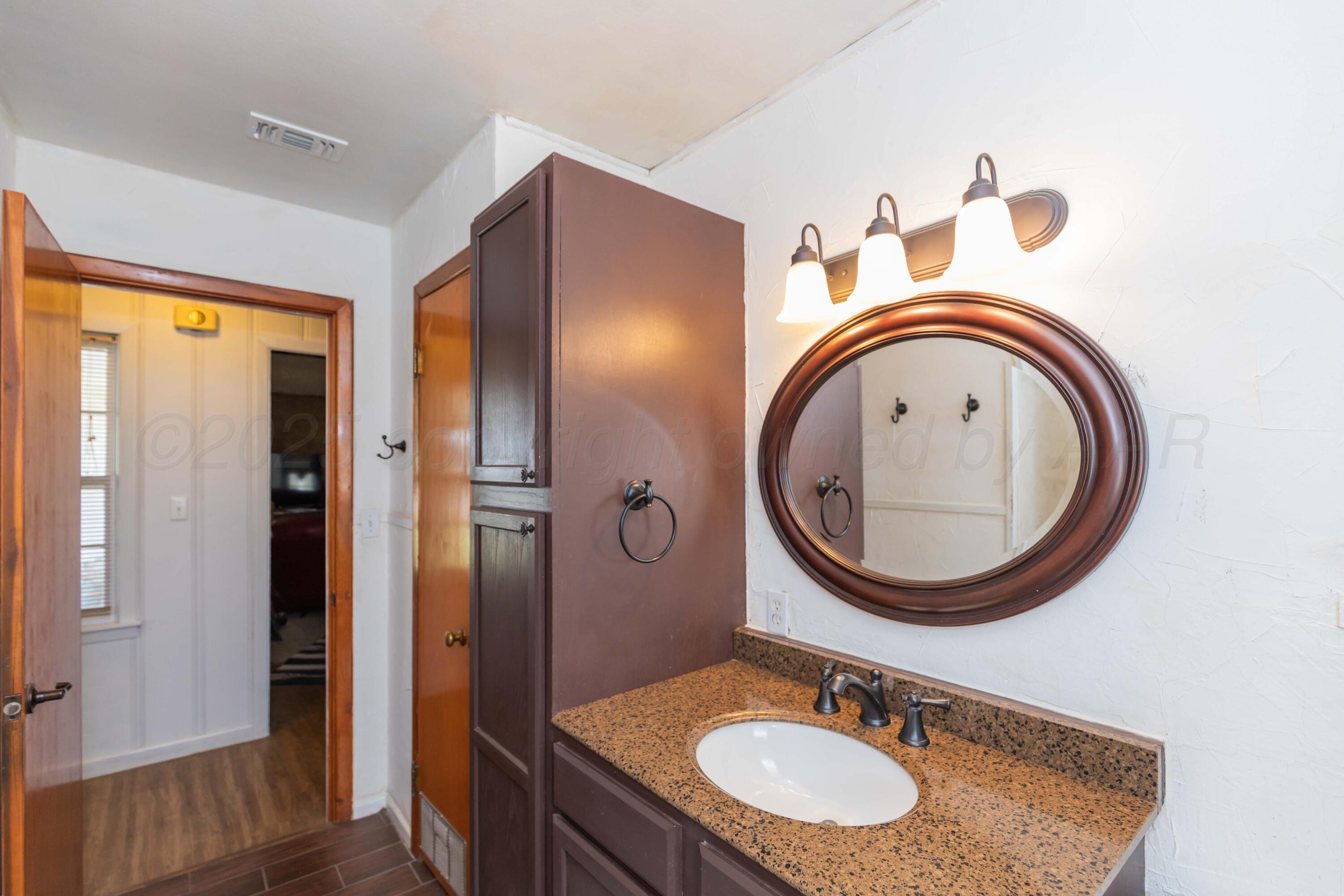 209 East 12th Street Wheeler, TX 79096 - Photo 26 of 40 a bathroom with a sink a mirror and a window