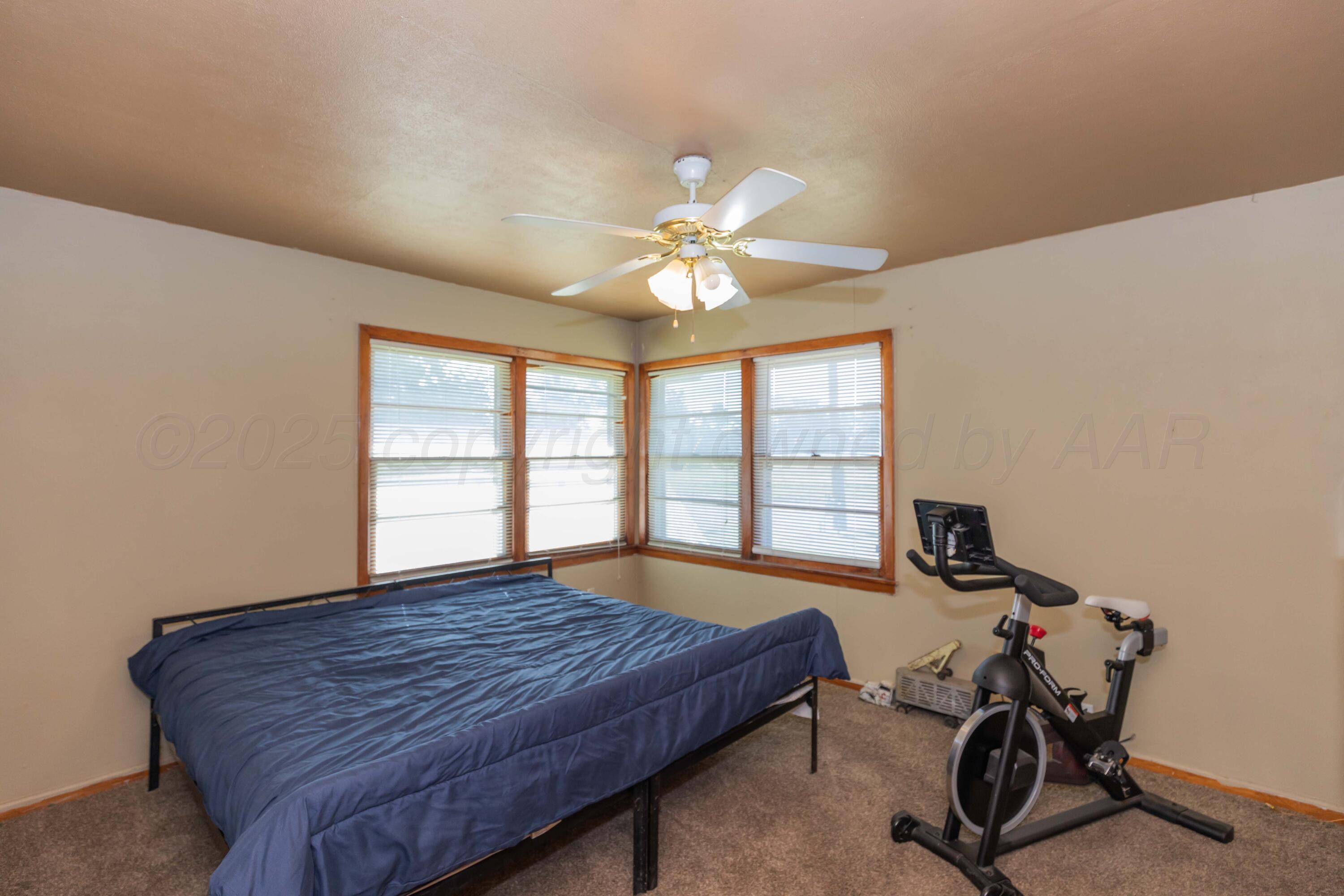 209 East 12th Street Wheeler, TX 79096 - Photo 28 of 40 a bed sitting in a room next to a window