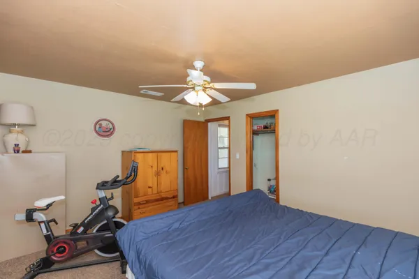 a room with gym equipment and wooden floor