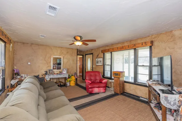 a living room with furniture and large windows