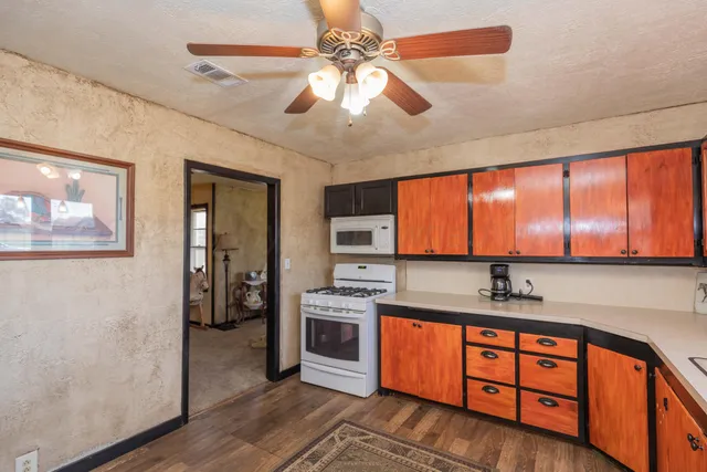 a kitchen with stainless steel appliances granite countertop a sink a stove and refrigerator