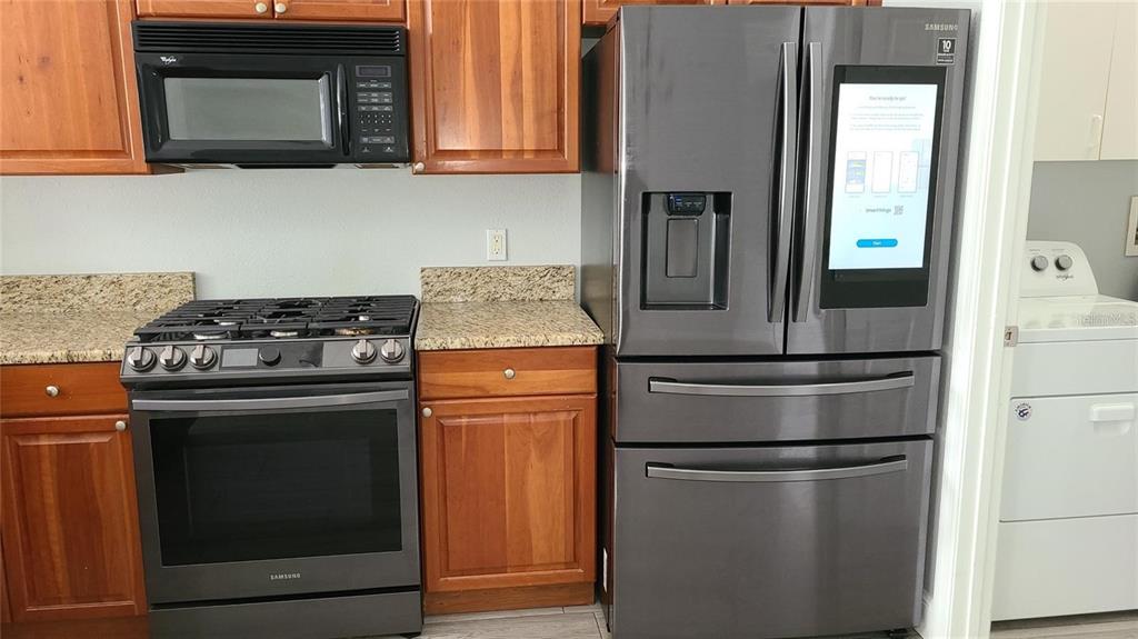 12518 Sparkleberry Road Tampa, FL 33626 - Photo 14 of 24 a kitchen with stainless steel appliances granite countertop a stove a refrigerator and a microwave