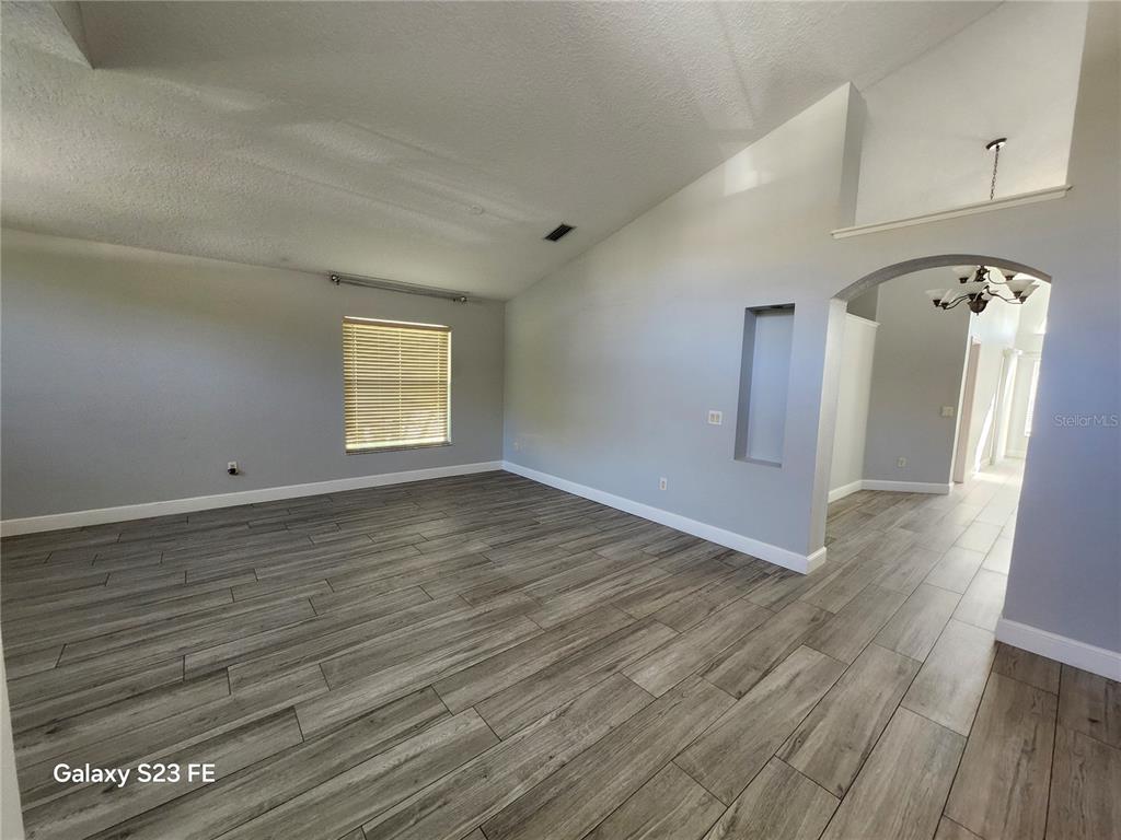 12518 Sparkleberry Road Tampa, FL 33626 - Photo 2 of 24 an empty room with wooden floor and windows