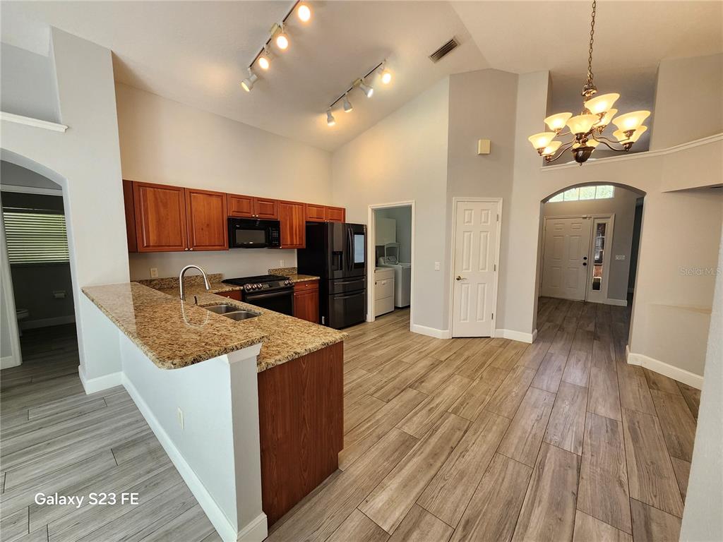 12518 Sparkleberry Road Tampa, FL 33626 - Photo 3 of 24 a open kitchen with stainless steel appliances granite countertop plenty wooden cabinets counter space a sink and wooden floor