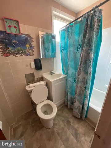 a white toilet sitting next to a shower curtain